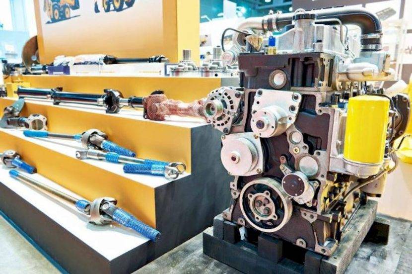 Un mecanic verifică piesele unui excavator JCB în atelier.