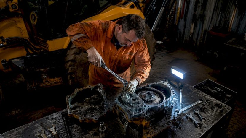 Mecanic la lucru, reparând transmisia unui Volvo BL71